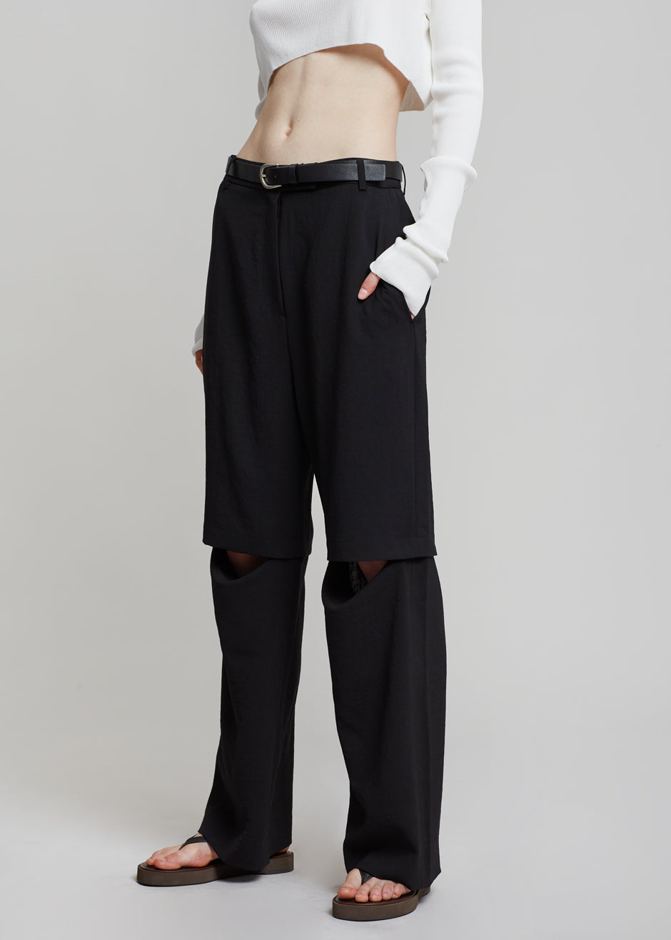 Ingrid Van De Wiele dark blue wide trousers with one open leg over shorts —  1990's - V A N II T A S