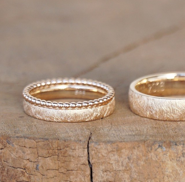 Zwei goldene Eheringe und ein dezenter Vorsteckring der nach der Hochzeit vor dem Ehering getragen wird.