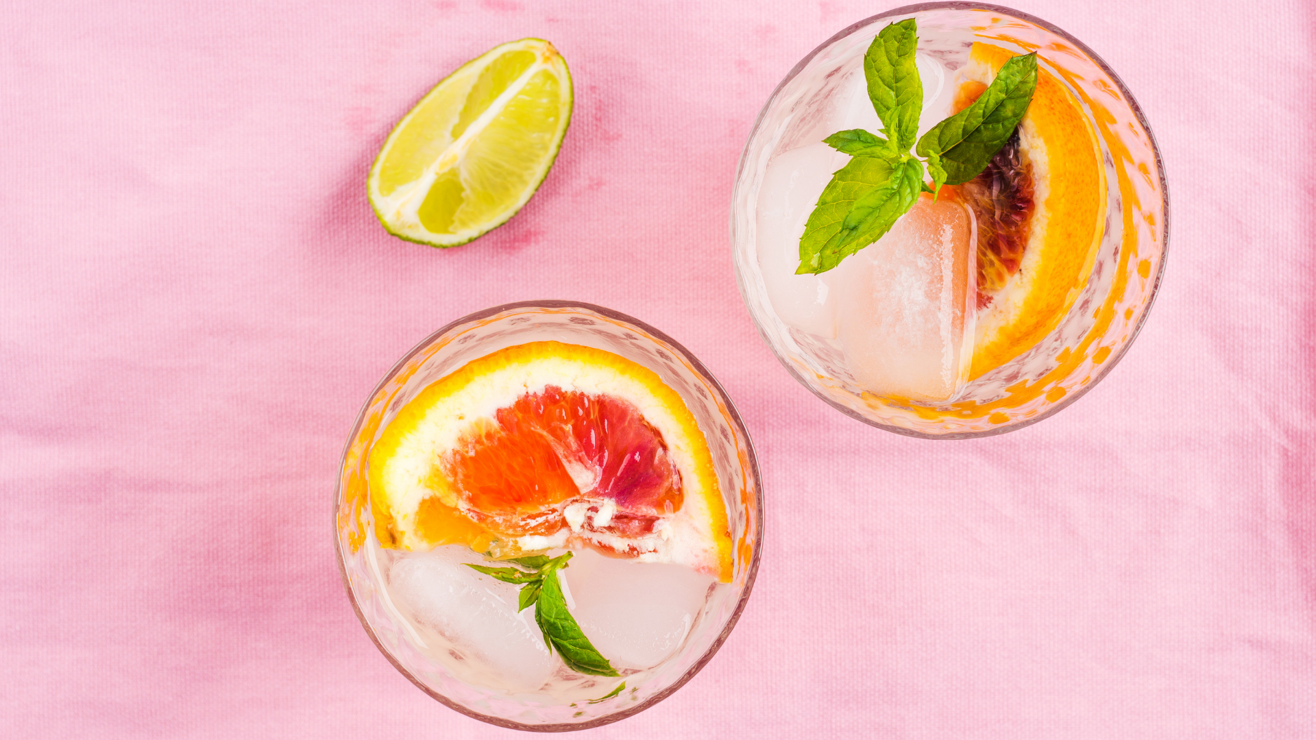 Mocktail with blood orange, passionfruit, guava, shrub in glass on pink background