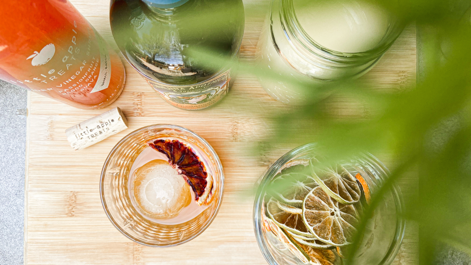 cocktail on cutting board with shrub, syrup and other ingredients 