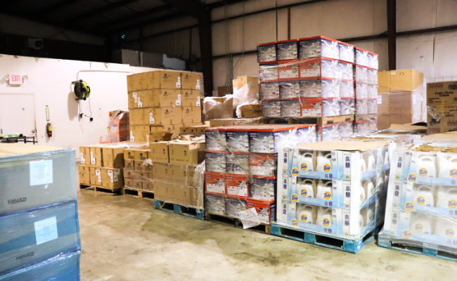 Warehouse filled with stacked pallets of name brand products - Wholesale & Liquidation Experts