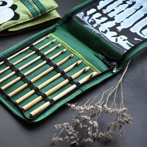 An image shows a set of wooden crochet hooks neatly arranged and packed inside a green fabric case. The case has multiple pockets, each of which holds a hook of a different size. The hooks are made of polished wood and have different sizes, indicated by numbers engraved on the handles. The image conveys an organized and well-maintained set of crochet tools, ready for use