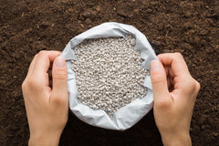 Open bag of fertilizer on soil