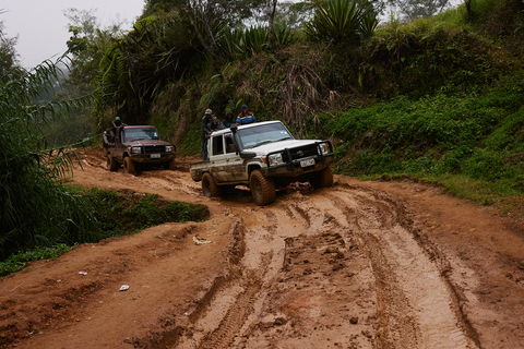 Two 4WD trucks navigate the muddy roads in PNG