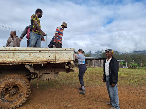 Caz climbing onto back of truck in Purosa, PNG