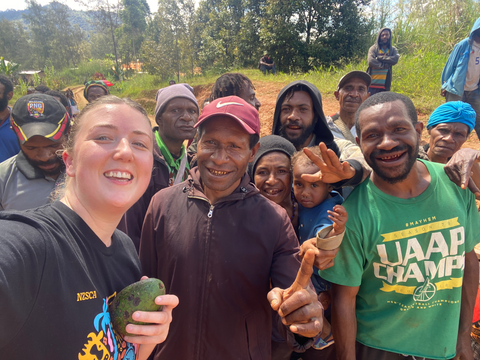 Caz with people in Keefu Village after being gifted an avocado