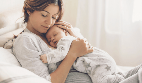 new mom sleeping with newborn baby on chest