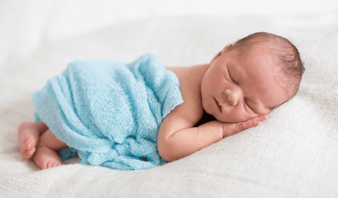 New born baby sleeping with blue blanker