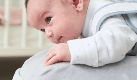 Newborn baby doing tummy time on the babocush comfort cushion