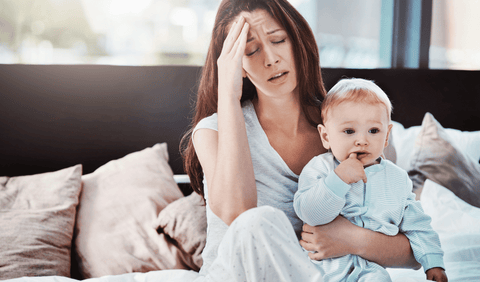 Tired stressed mom holding baby boy