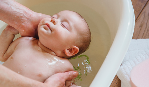 New born baby in a oatmeal milk bath to help with Diaper Rash Relief