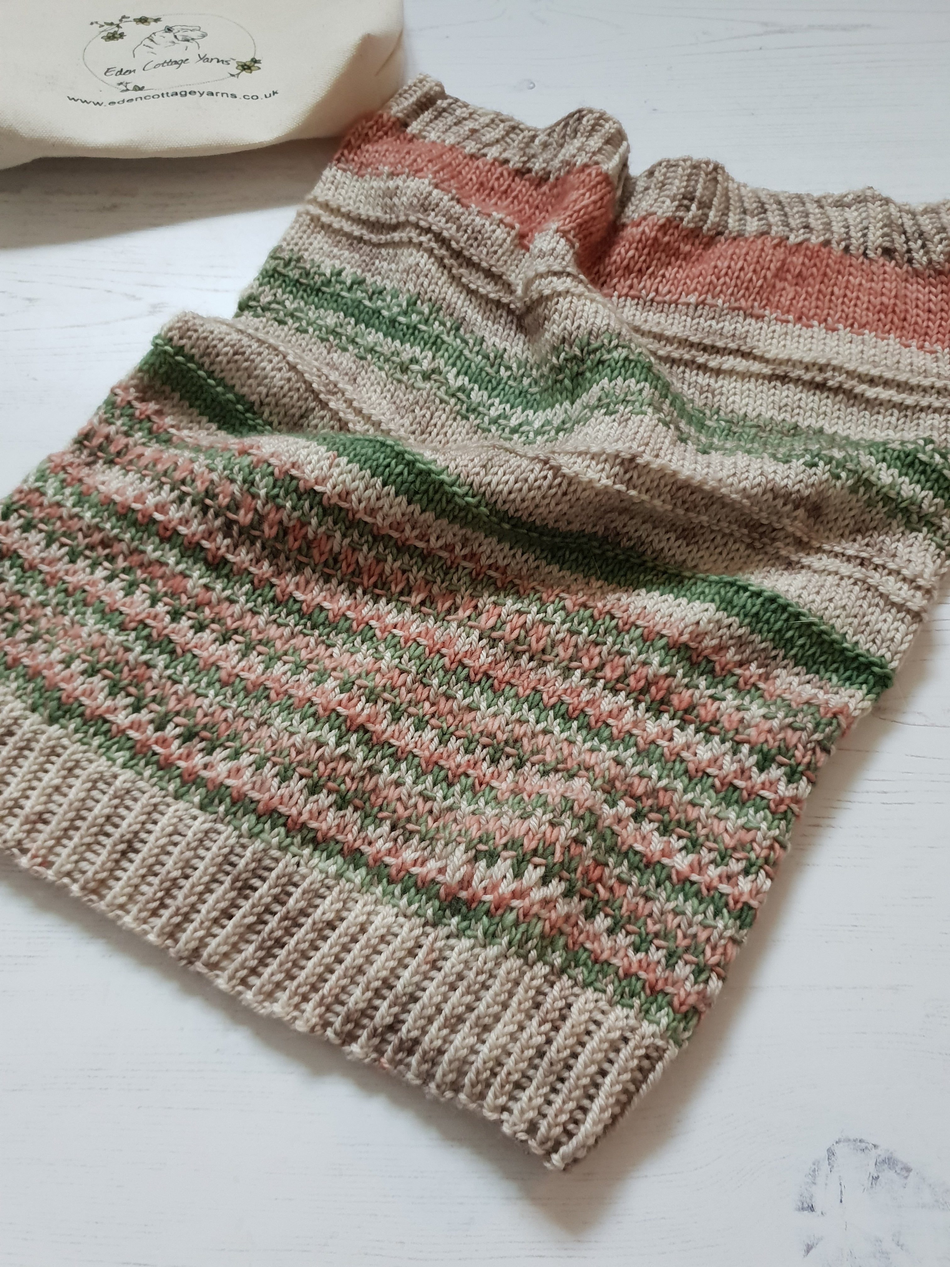 A beige cowl with red and green colourwork details