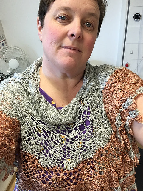 Heidi wearing a two tone lace shawl. The shawl features intricate patterns and is part grey and part brown