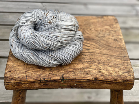 Grey tweed yarn on a wooden stool