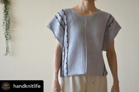 a woman is modelling a knitted tee