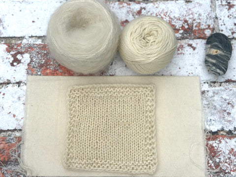 a fluffy knitted swatch which looks off-white, the same as the yarns