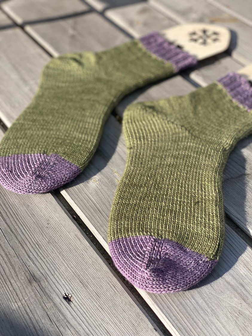 Green machine knit socks with purple toes and cuffs