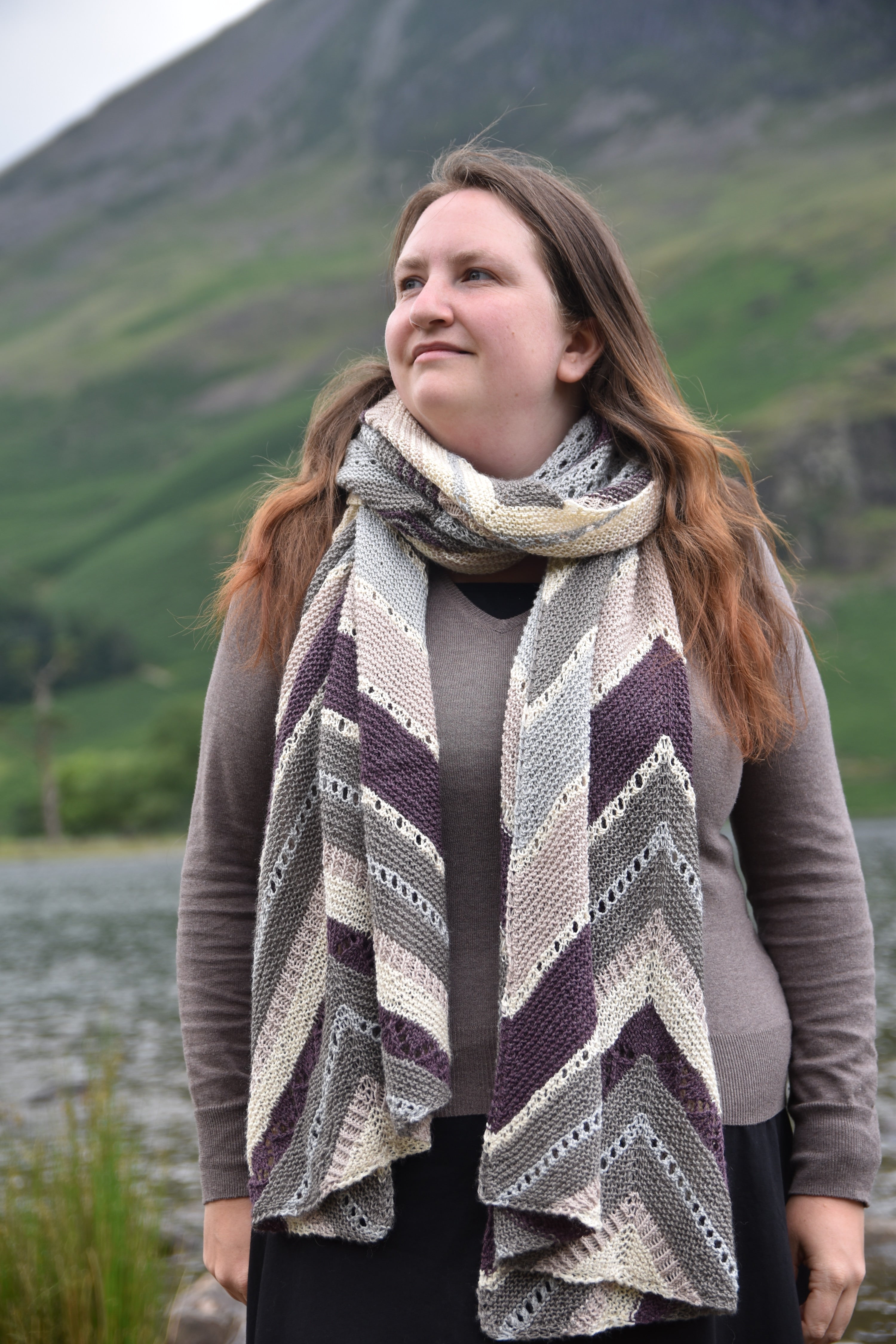 Victoria wearing a long rectangular wrap with chevron details in beige, purple, blue and grey