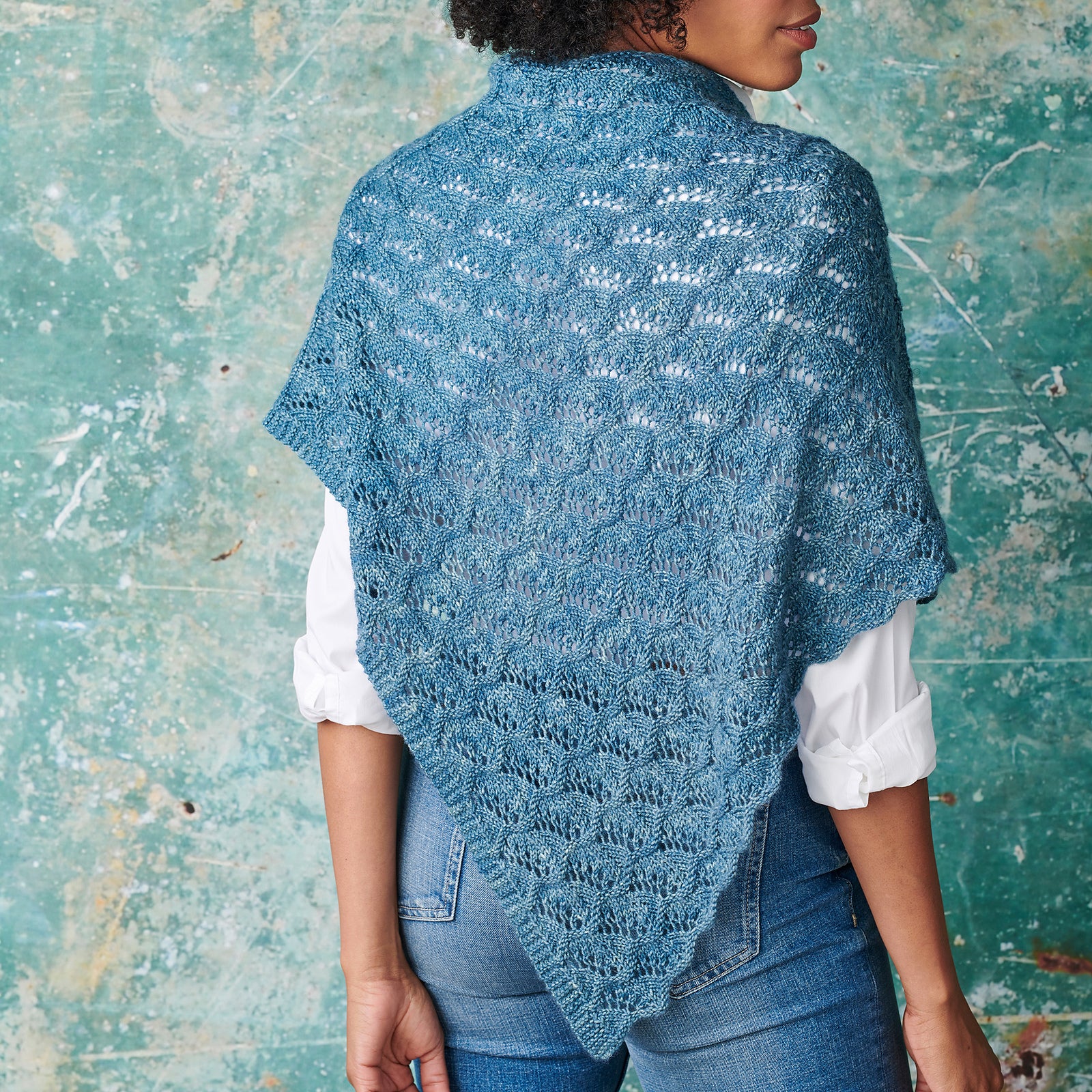 A blue triangular shawl with all over lace detailing