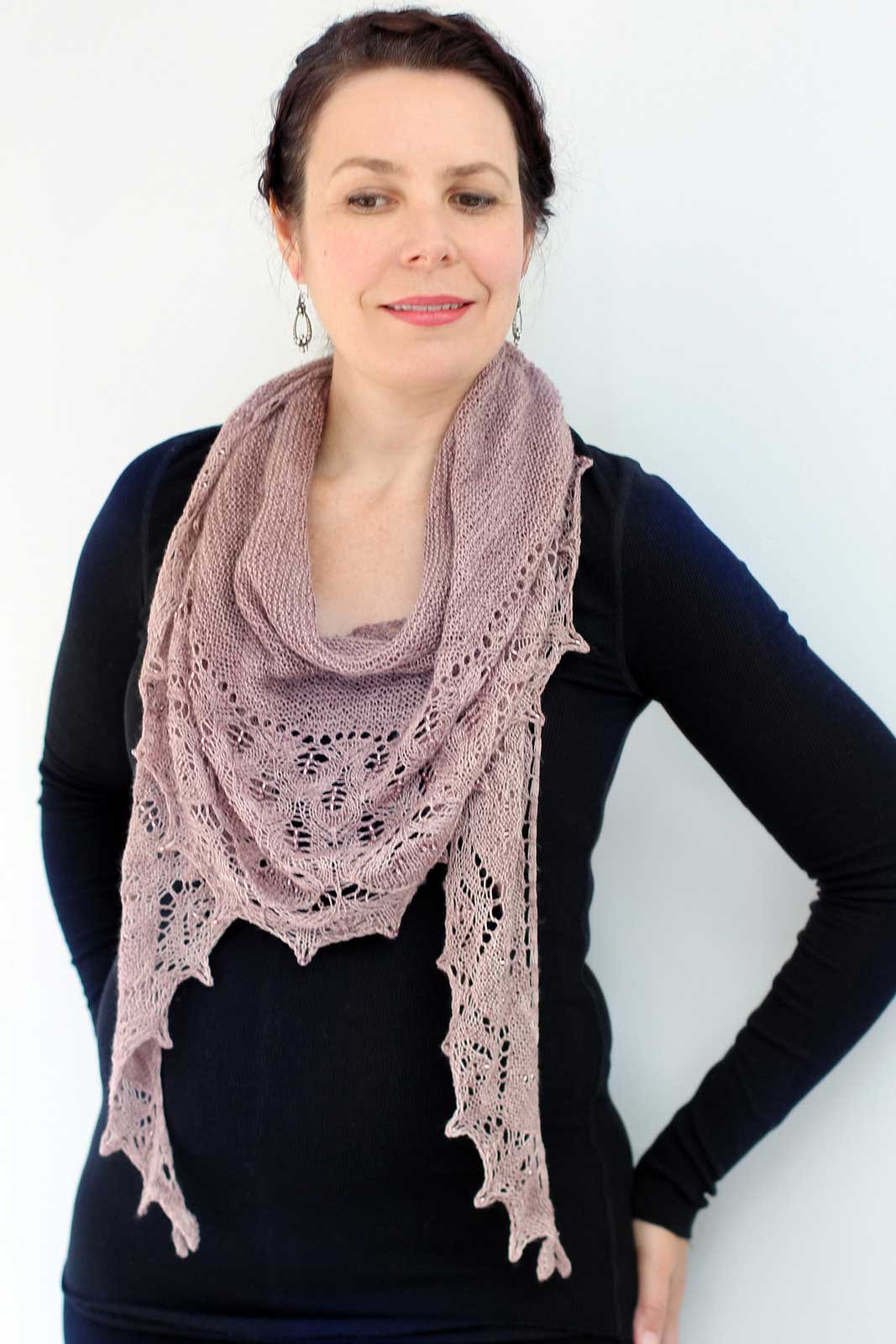 Helen stood in front of a white backdrop wearing a black top and a pinky beige shawl. The shawl includes lace details and small beads