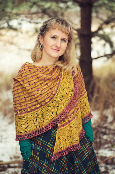 Justyna wearing a yellow and red shawl with stripe details and a lace border draped around her shoulders