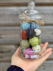 A jar full of mini balls of yarn