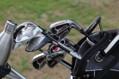 beginner set of golf clubs for amateur players in a golf bag in a green grass field