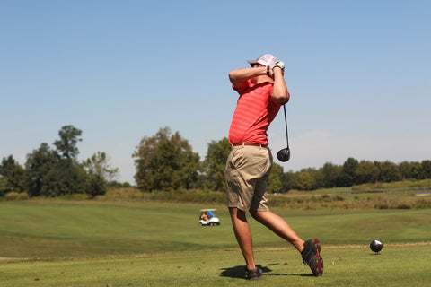 golfer swinging golf club fast to hit the ball in a golf course