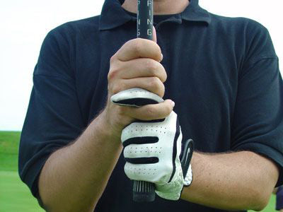 Golf player holding a golf club with the interlocking golf grip