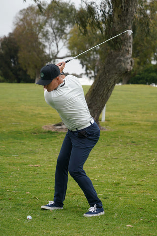 player about to hit a golf ball swinging a golf ball