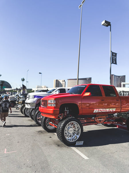 Customized, lifted trucks displayed outside SEMA 2023.