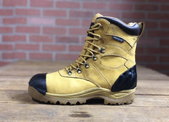 Work boot featuring a heel guard and TUFF TOE reinforcement on the toe cap, displayed against a brick wall backdrop.