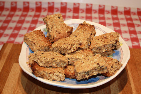 A plate of delicious looking granola bars on a pottery dish with a red-checked tablecloth