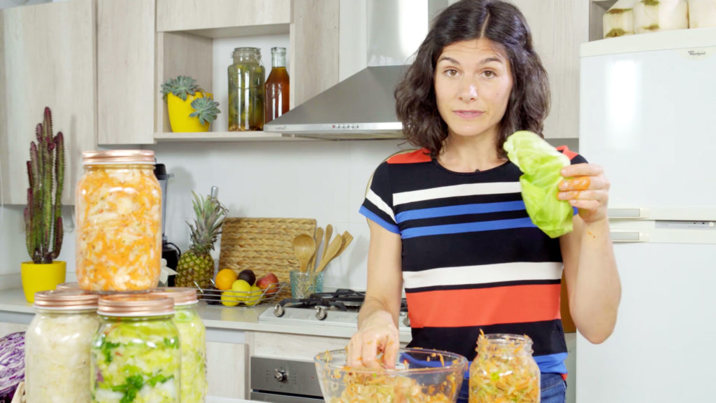 woman holding cabbage in a striped shirt