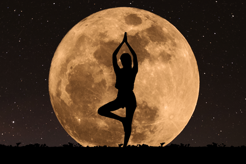 woman doing yoga in front of the moon 