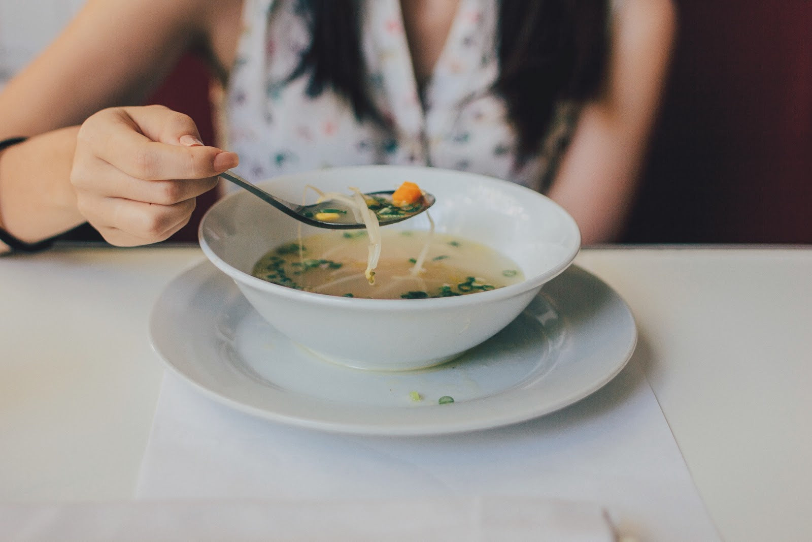 A woman eats soup