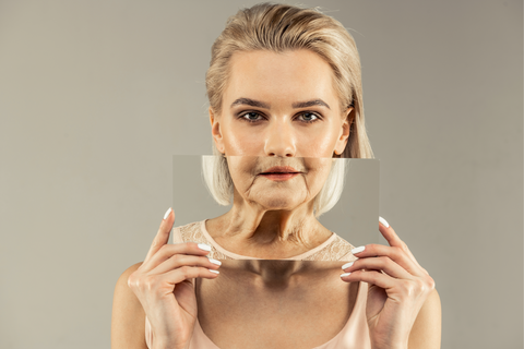 Young woman holding old woman's face in front of hers