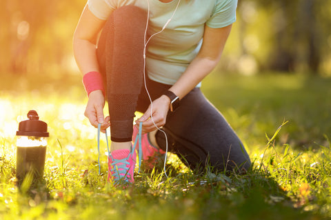 Woman running and drinking green smoothie for detox