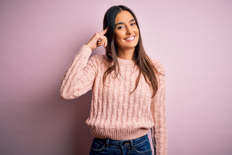 woman in pink pointing to her brown hair 