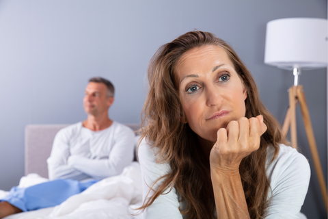 woman in bed with frustrated man