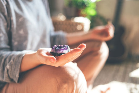 woman holding crystal meditating 
