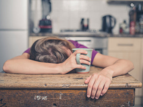 exhausted woman holding a coffee cup