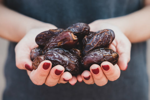 woman holding dates in her hands with red nails