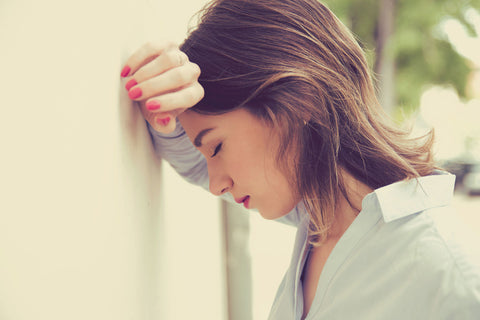 woman leaning her head against the wall