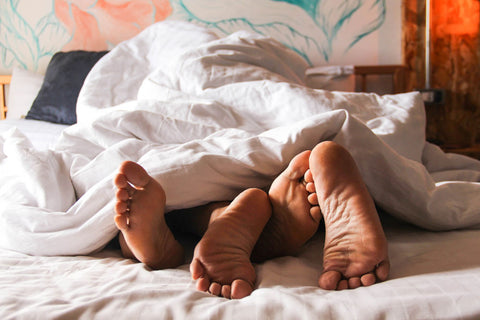 feet of a couple in bed 