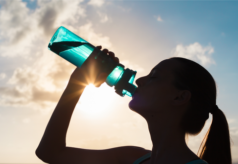 woman drinking water in the sun