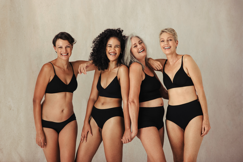 Four women in black underwear laughing together