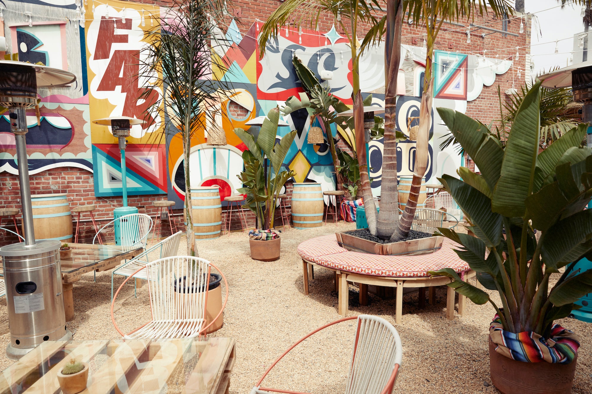 An asphalt parking lot that has been turned into a tropical outdoor dining area which is part of Heather Tierney's concept, De Buena Planta.