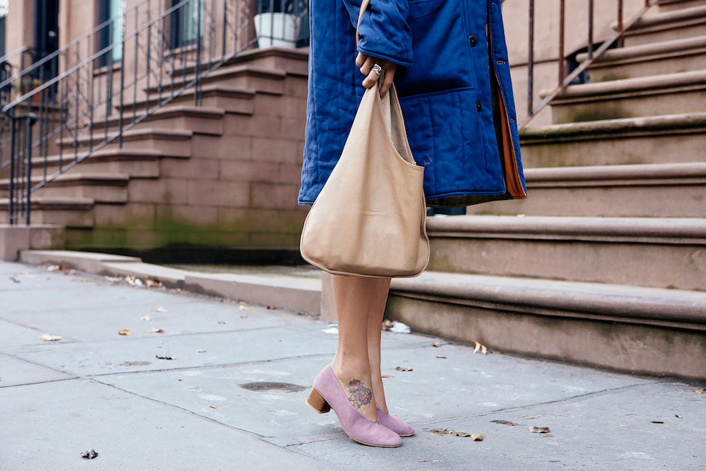 Waist-down shot of Elise Peterson in a blue coat sporting the Coclico Narwhal Heel in Viola suede.