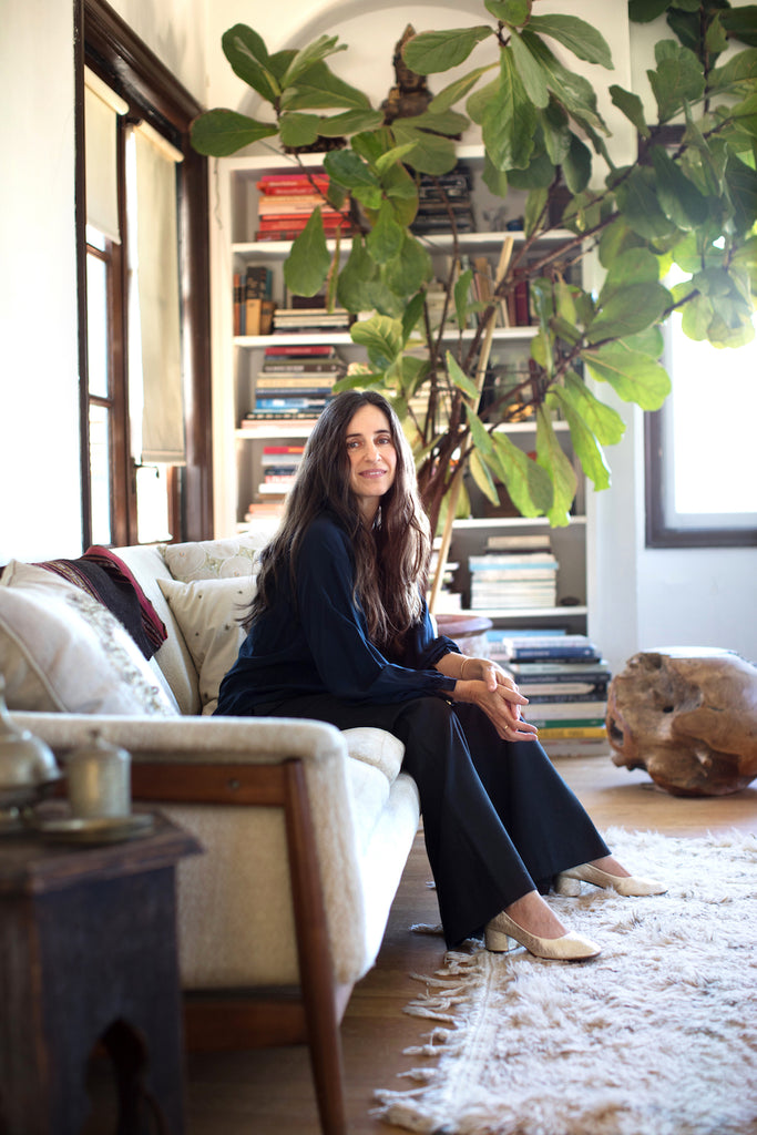 Erica, the designer, founder, and owner of Erica Tanov – a women’s clothing and home goods brand with three retail stores sitting a couch. 